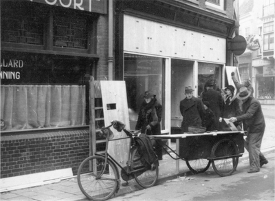 603107 Afbeelding van het met panelen beschermen van de winkelpui van het Magazijn in feestartikelen De Voordracht ...